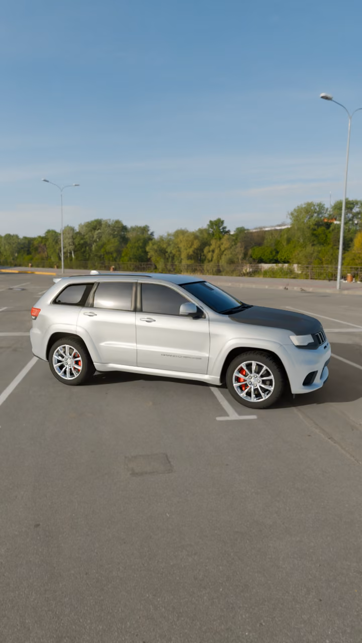 A silver Jeep Grand Cherokee SRT with a carbon hood with 35% window tint